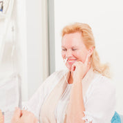 Lachende vrouw met rood licht therapie laser in de neus